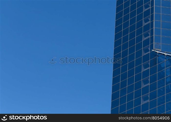 Glass building windows reflection on blue sky