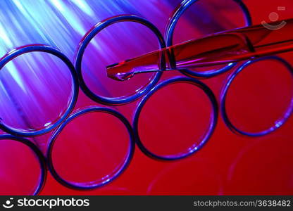 Glass chemistry tubes on a colour background