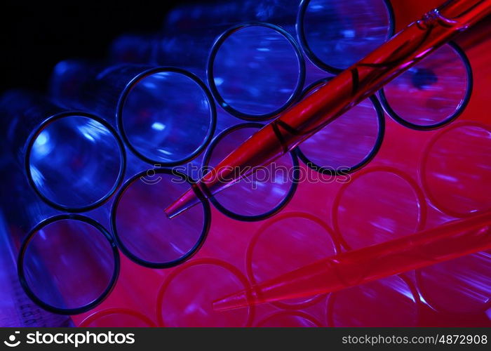 Glass chemistry tubes on a colour background