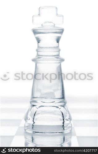 glass chess king is standing on board, cut out from white background