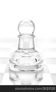glass chess pawn is standing on board, cut out from white background