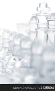 glass chess pieces are standing on board, cut out from white background