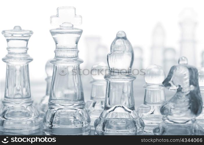 glass chess pieces are standing on board, cut out from white background