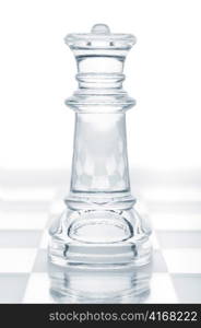 glass chess queen is standing on board, cut out from white background