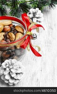 Glass Christmas jar with hazelnuts,almonds and nuts.Copy space