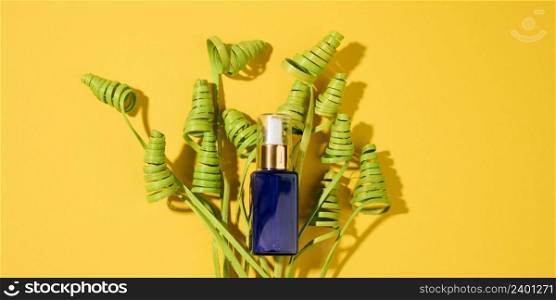 glass cosmetic blue bottles with a pipette on a yellow background. Cosmetics SPA branding mockup, top view