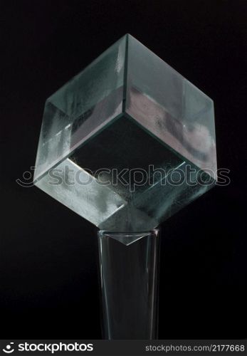 glass cube on a shot glass, on a black background