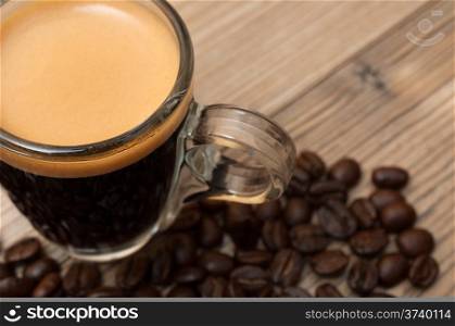 Glass Cup of Espresso Coffee on Wooden Table With Coffee Beans - Shallow Depth of Field