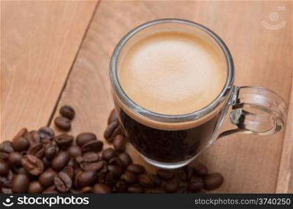 Glass Cup of Espresso Coffee on Wooden Table With Coffee Beans With Copyspace - Shallow Depth of Field