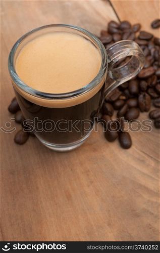 Glass Cup of Espresso Coffee on Wooden Table With Coffee Beans With Copyspace - Shallow Depth of Field
