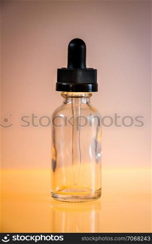 Glass dropper bottle and pipette on orange background. Glass dropper bottle on orange background