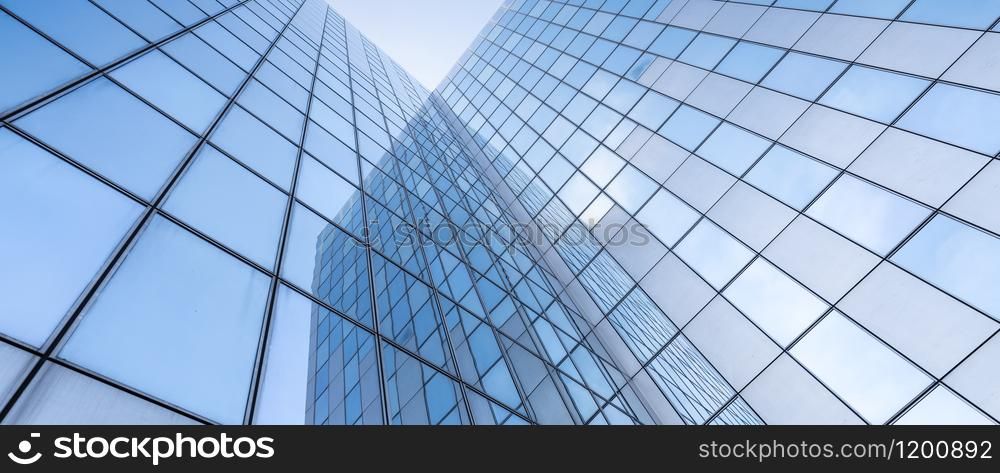 glass facades of modern office buildings and reflection of blue sky and clouds