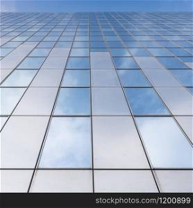 glass facades of modern office buildings and reflection of blue sky and clouds