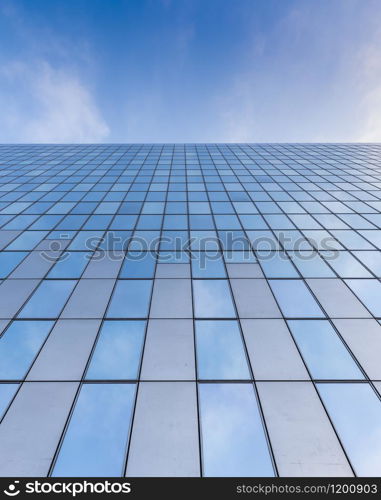 glass facades of modern office buildings and reflection of blue sky and clouds