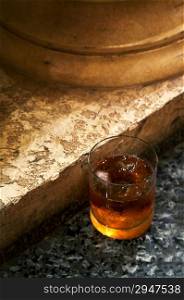 Glass from whisky on marble to a floor