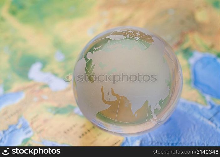 Glass globe on map