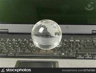 glass globe placed on a laptop