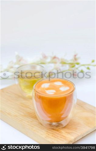 Glass hot thai tea cup. Glass hot thai tea cup with white foam surface and hot tea