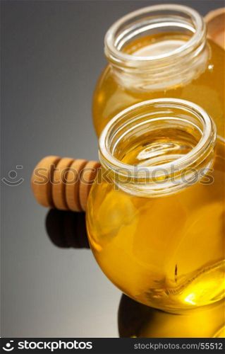glass jar full of honey on black background