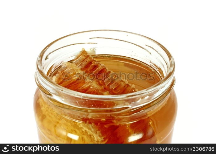 Glass jar full of honey with honeycomb, isolated on white