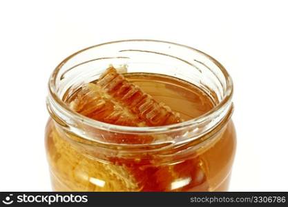 Glass jar full of honey with honeycomb, isolated on white