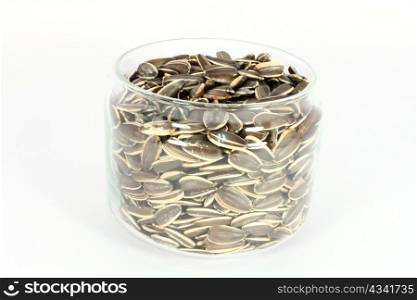 Glass jar full of unshelled sunflower seeds, isolated on white
