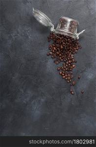 Glass jar of fresh raw organic coffee beans on black background. Top view. Space for text.