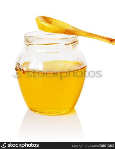 Glass jar of golden honey with a wooden spoon