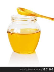 Glass jar of golden honey with a wooden spoon