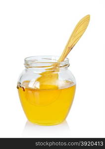 Glass jar of golden honey with immersed in it a wooden spoon