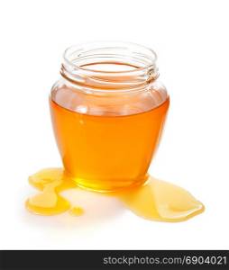 glass jar of honey and drop isolated on white background