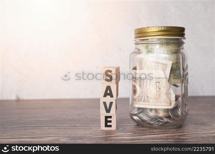 glass jar savings with wooden word