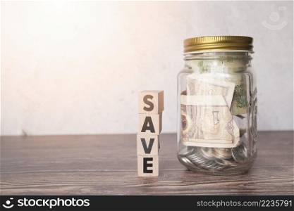 glass jar savings with wooden word