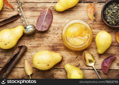 Glass jar with autumn homemade pear jam. Homemade pear jam on wooden table