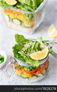 Glass jar with fresh raw vegetables and couscous groats. Healthy Meal Prep - recipe preparation photos. Healthy vegan dishes in glass containers. Weight loss food concept. Homemade Salad in a jar.