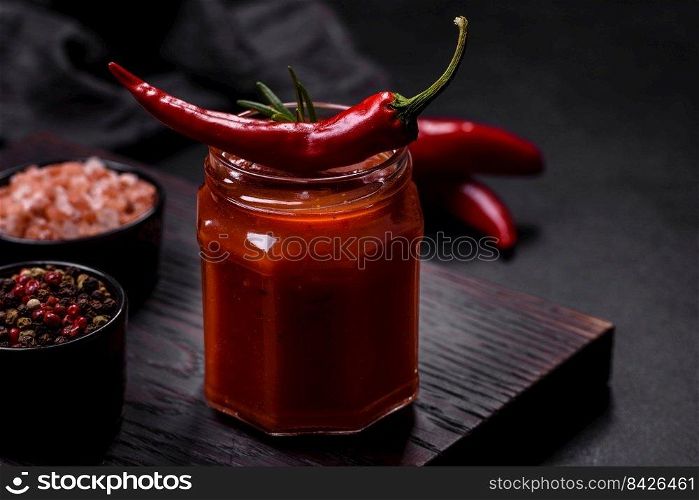 Glass jar with homemade classic spicy tomato pasta or pizza sauce with spices and herbs. Italian healthy food background. Glass jar with homemade classic spicy tomato pasta or pizza sauce with spices and herbs
