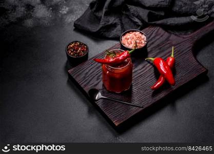 Glass jar with homemade classic spicy tomato pasta or pizza sauce with spices and herbs. Italian healthy food background. Glass jar with homemade classic spicy tomato pasta or pizza sauce with spices and herbs