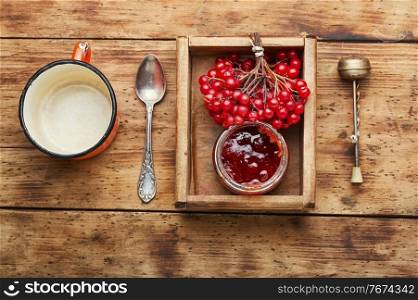 Glass jar with jam and fresh viburnum berries. Viburnum berry jam