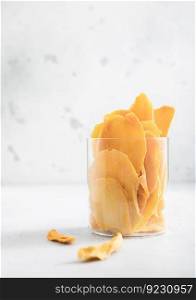 Glass jar with large sweet dried mango slices.Macro
