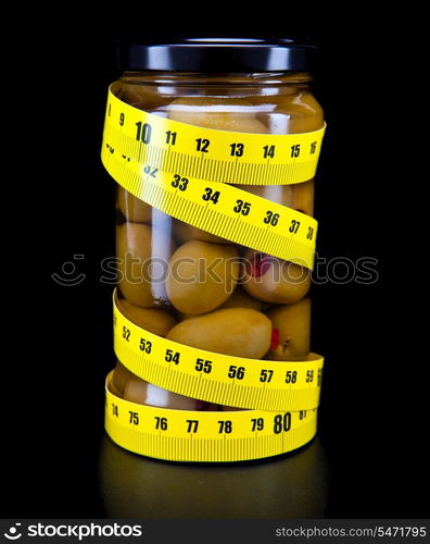 Glass jar with olive and measuring tape- healthy food