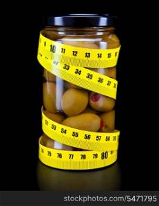 Glass jar with olive and measuring tape- healthy food