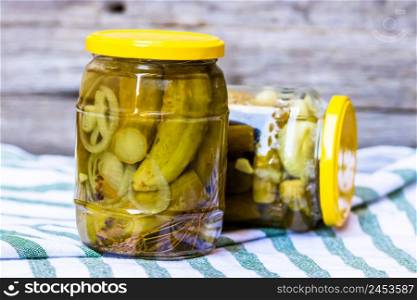 Glass jar with pickles isolated. Preserved food concept, canned vegetables isolated in a rustic composition.