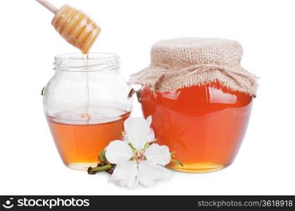 glass jars with honey and wooden stick isolated on white background