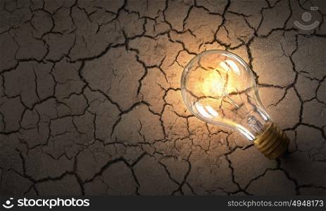 Glass light bulb. Close up of glowing light bulb in desert