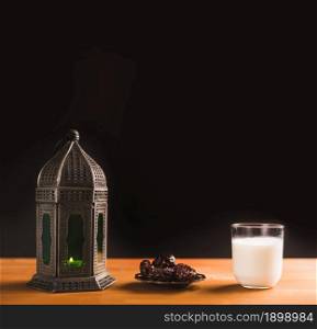 glass milk near saucer with sweet prunes lantern. Resolution and high quality beautiful photo. glass milk near saucer with sweet prunes lantern. High quality beautiful photo concept