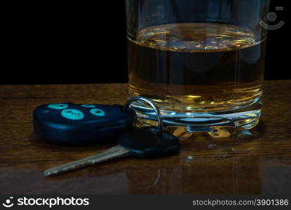 Glass of alcohol and car keys on the bar