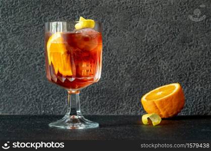 Glass of Americano cocktail garnished with orange slice and lemon zest