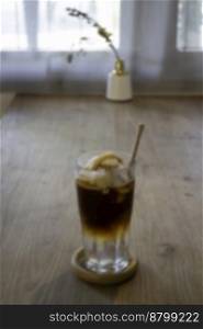 Glass of americano mixed with craft soda and yuzu orange juice blur background, stock photo