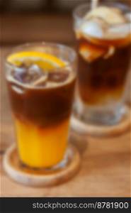 Glass of americano mixed with orange juice blur background, stock photo