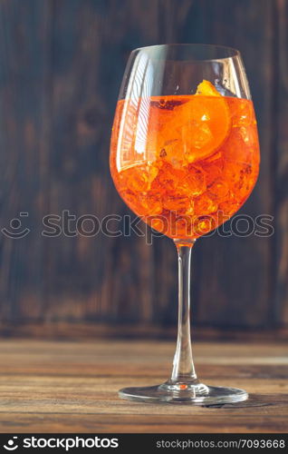 Glass of Aperol Spritz cocktail on the rustic background